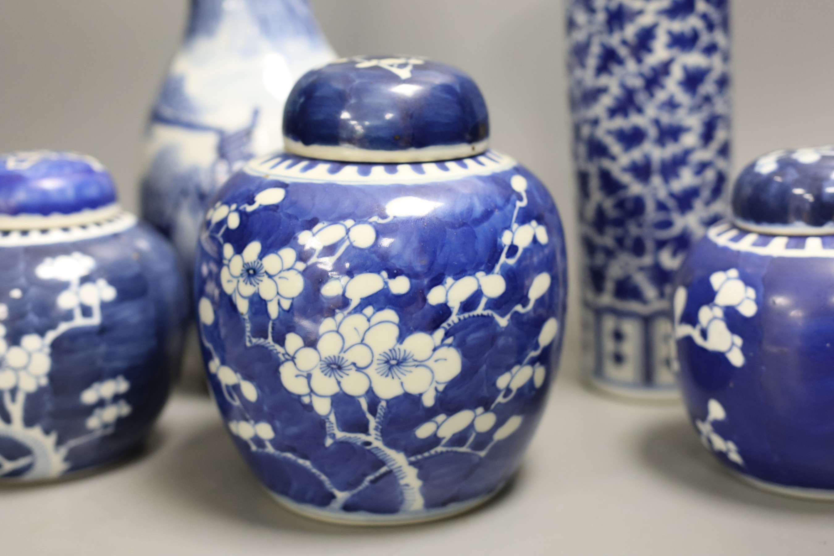 A 19th century Chinese blue and white ‘landscape’ vase, an early 20th century blue and white sleeve vase and three blue and white jars and covers. Tallest 25.5cm